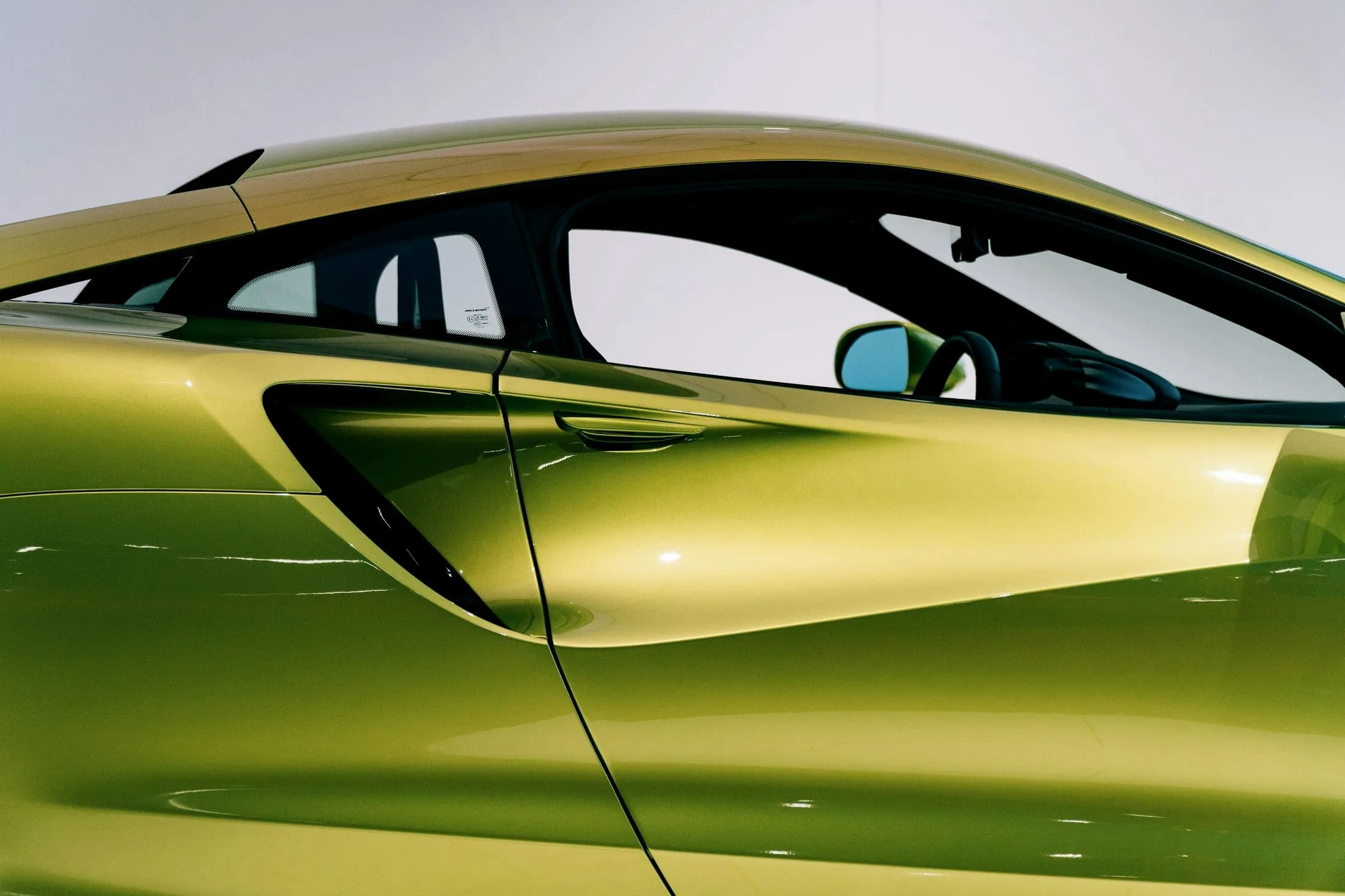 Dihedral door line and side intake of a green McLaren Artura