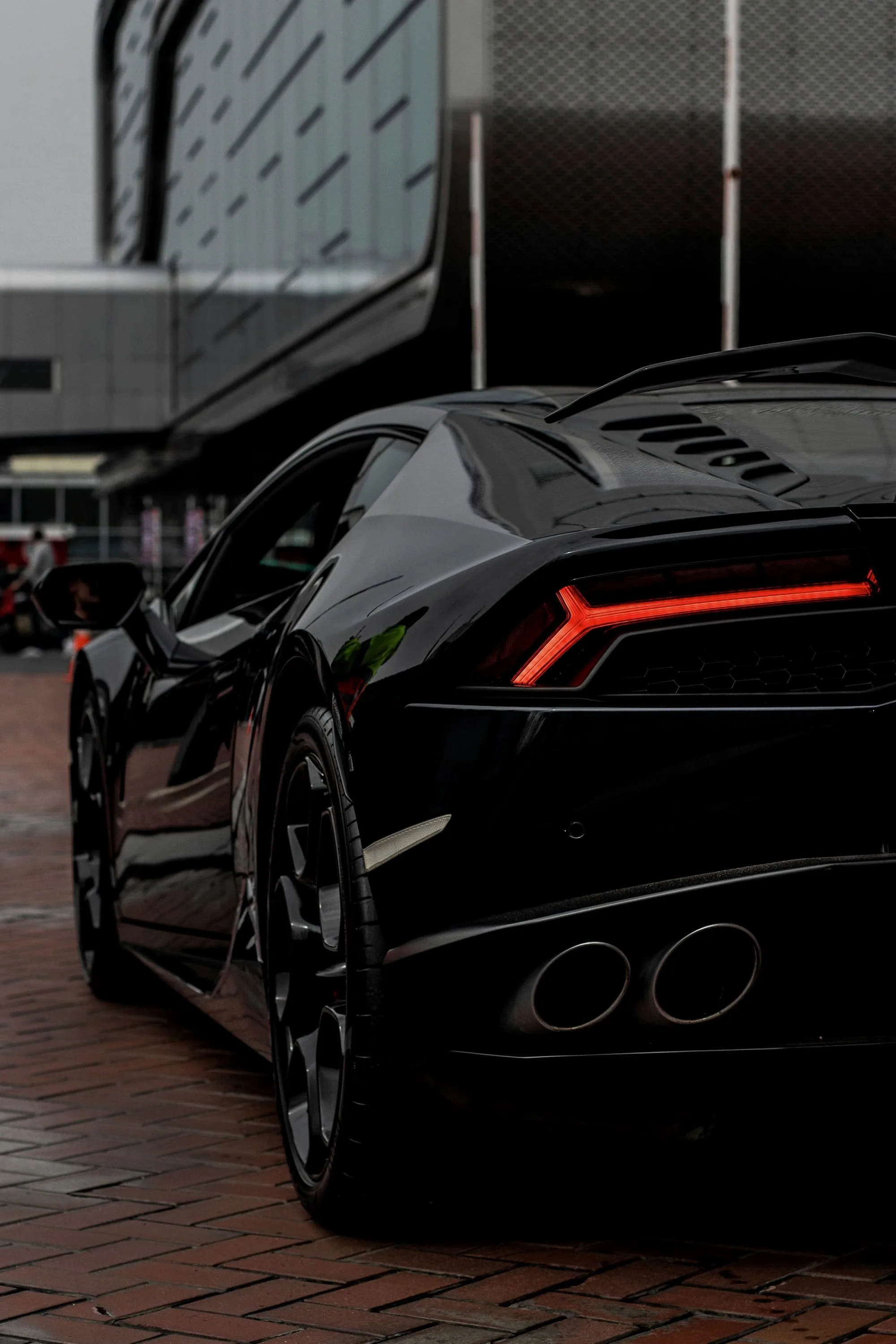 Rear haunch and Y-shaped tail light of a black Lamborghini Huracán