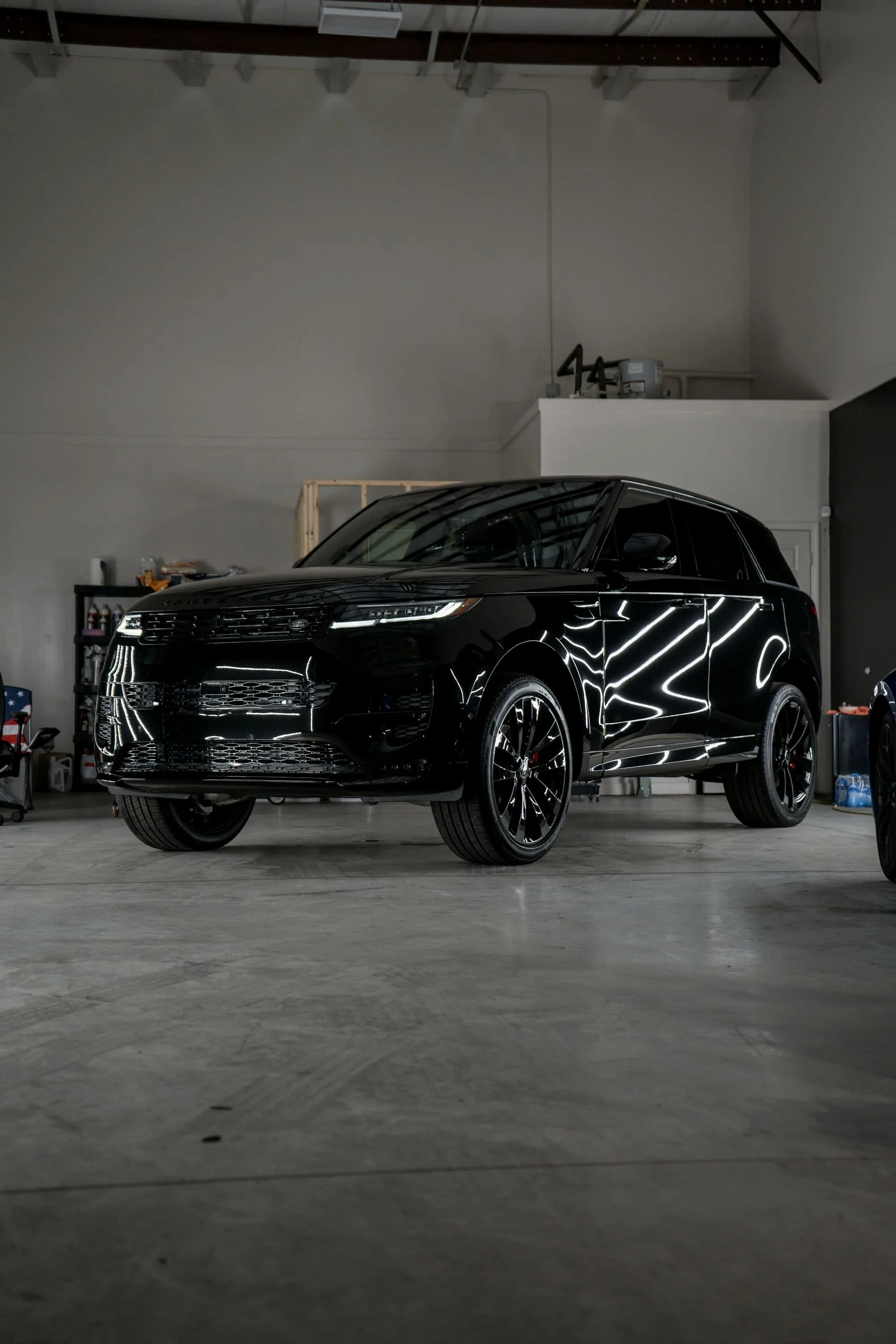 Black Range Rover Sport SV in a white-walled studio garage