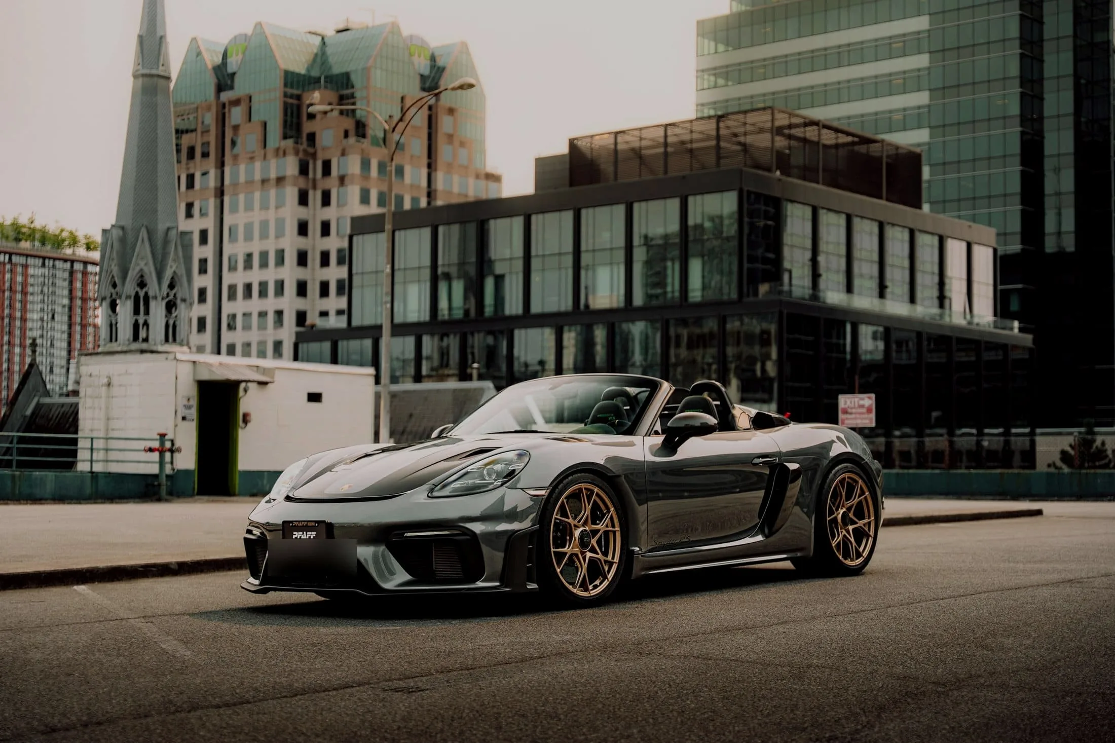 Grey Porsche 718 Spyder RS with bronze wheels and the roof down