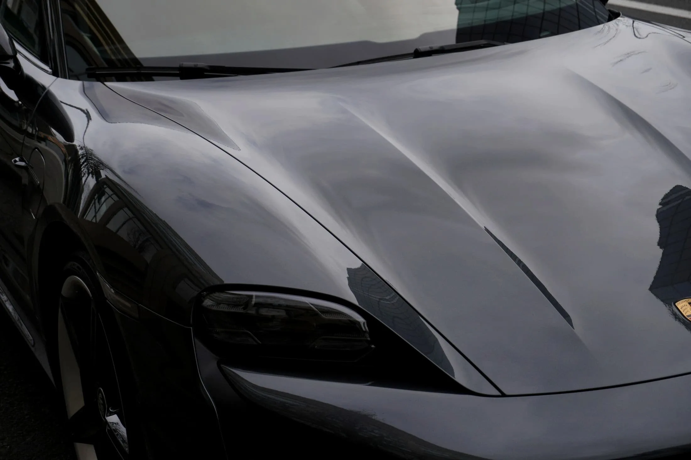 Close view of the sculpted bonnet of a black Porsche Taycan